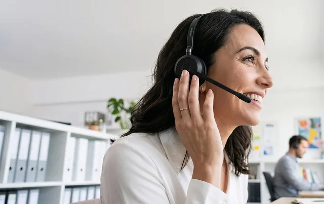 office, headset, smiling woman, headset microphone, workplace, interaction, call center, conversation, professional, communication, customer service, woman, smile, white shirt, satisfaction, working, happy worker, administrative, telephone call. Common Customer Retention for Small Businesses Questions
